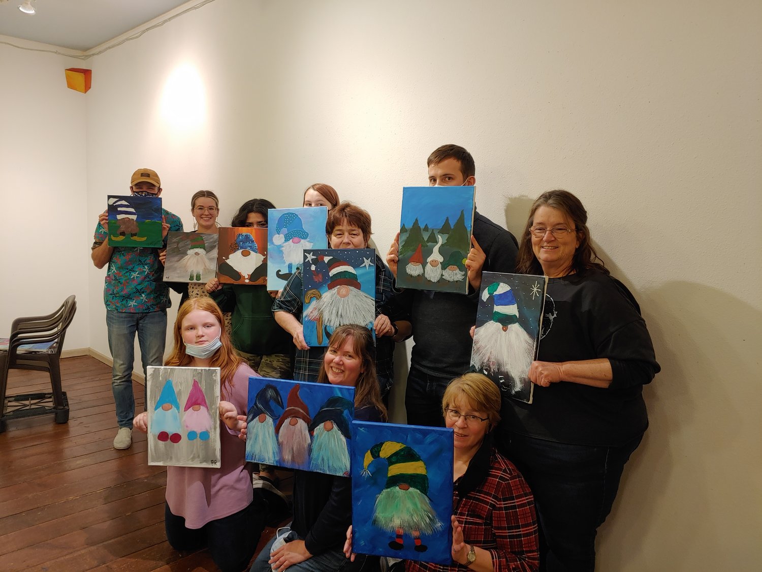 Participants hold up their paintings in this photograph provided by Julie McDonald.